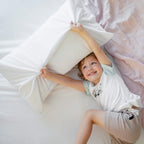 Child playing under the Conni Micro-Plush Waterproof Sheet (King) on a bed