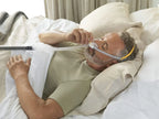 Man lying in bed wearing the Fisher and Paykel Solo Nasal Pillow Mask